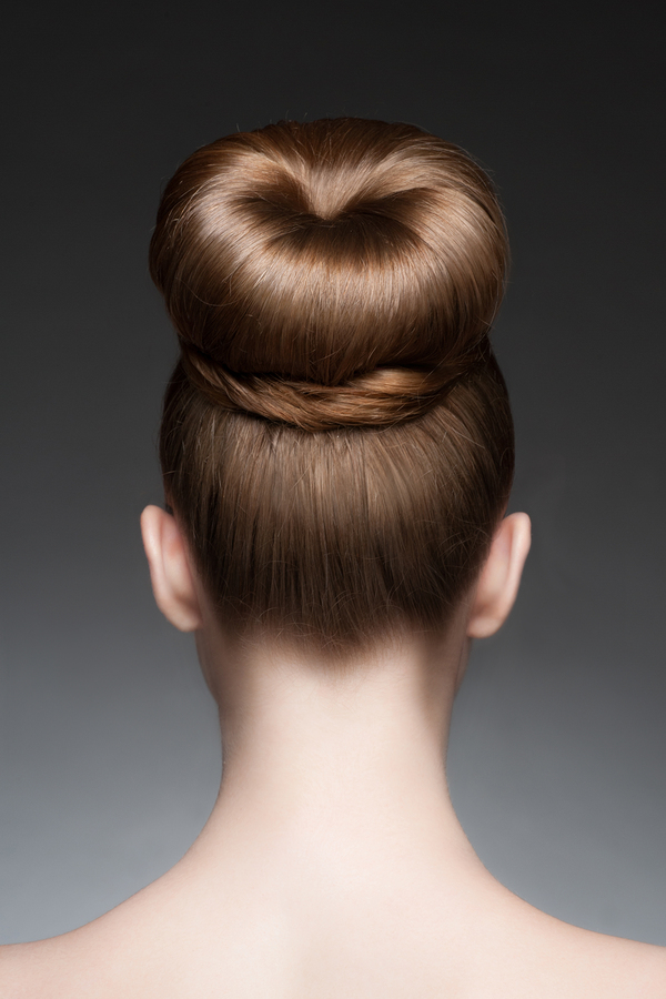 Portrait of young beautiful woman with creative elegant hairstyle, hair bun. Rear view
